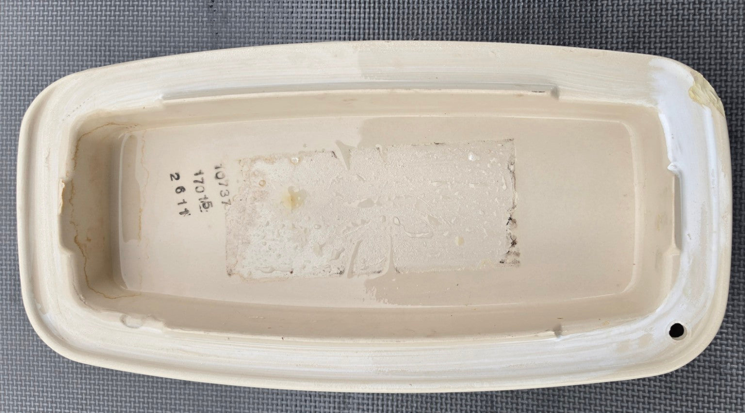 Kohler 1033723 almond toilet tank lid underside showing stamped number